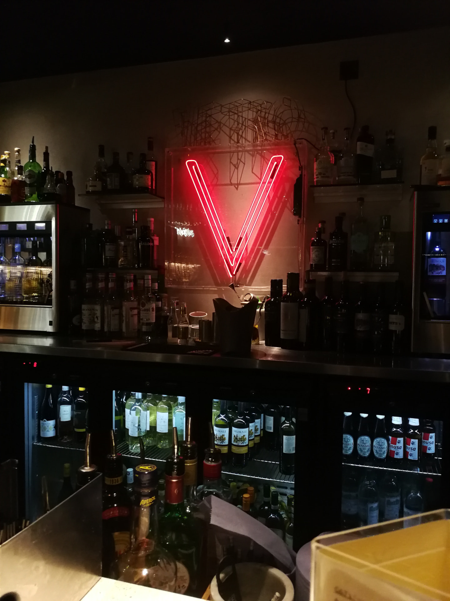 The neon V sign behind the bar at Vetro