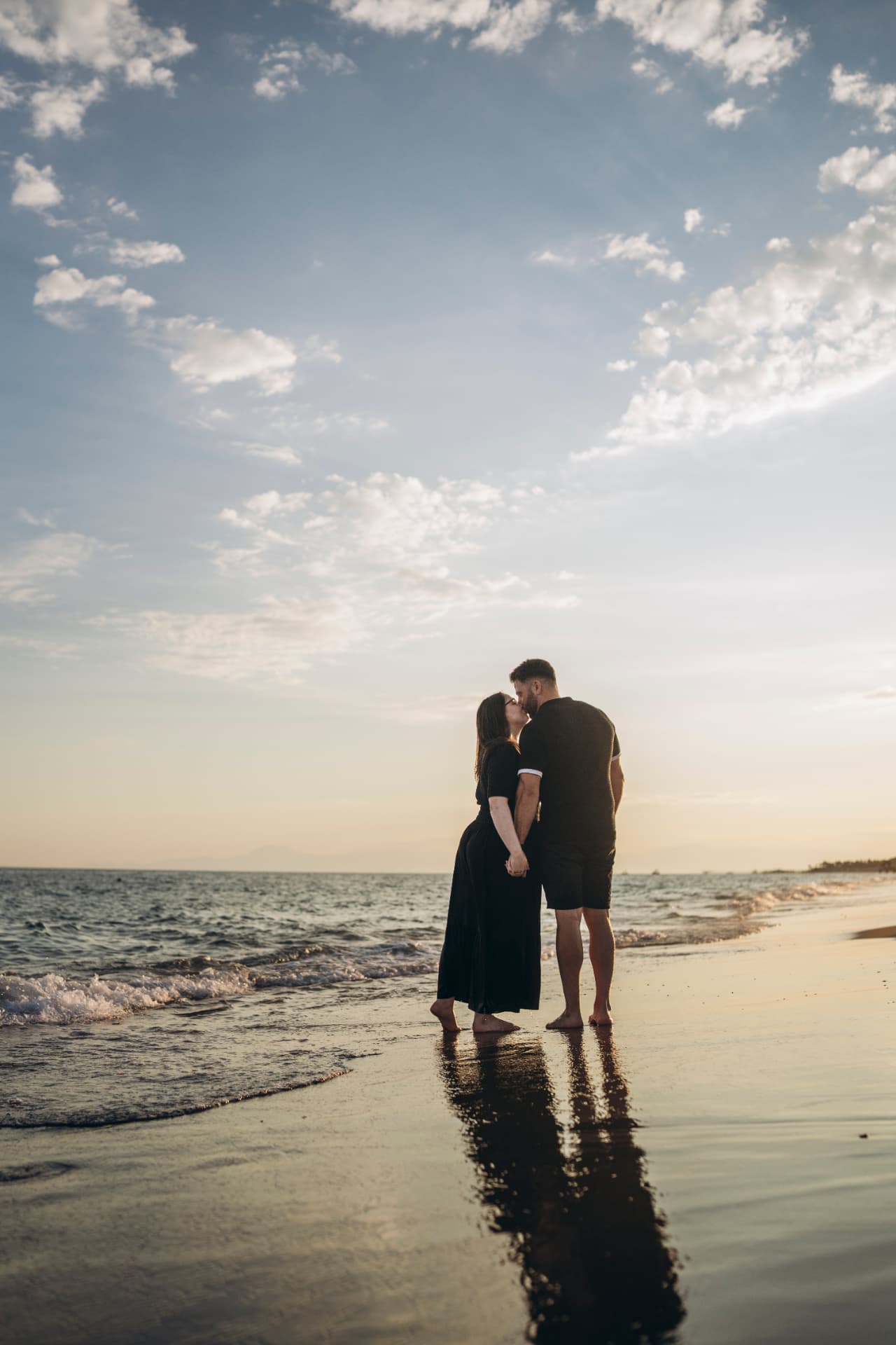 Adem and Fran kissing on the beach at sunset