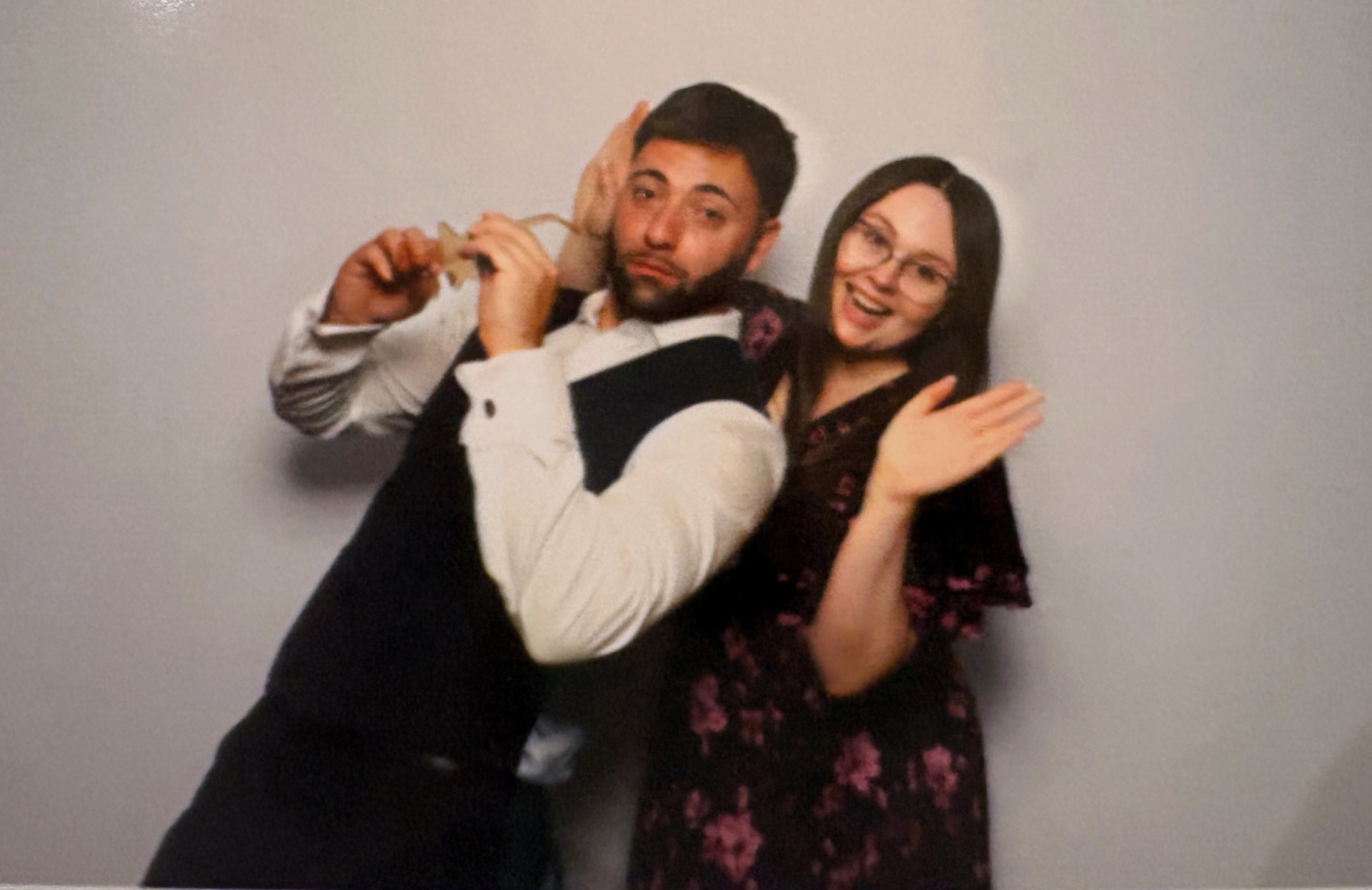 Adem and Fran smiling together in a photo booth